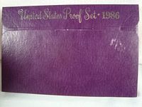 Purple outer cardboard envelope with 'United States Proof Set 1986' embossed in gold showing shelf wear.