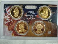 Obverse side of four Presidential $1 proof coins showing portraits of James Monroe, Andrew Jackson, Martin Van Buren, and John Quincy Adams in sealed mint packaging.