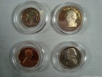 Four 1988 US proof coins including penny, nickel, dime, and quarter in round airtight protective cases, displayed on a white textured surface.