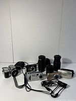 Full overview of all cameras, lenses, cases and cable on white background
