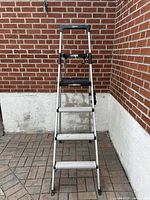 Full front view of the aluminum step ladder showing four steps and brand logo on the top.