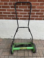 Front view of the green and yellow EZ Tools reel lawn mower with black handles and two large wheels, showing overall condition and design.