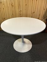 Full view of white round table showing shape, color, and condition