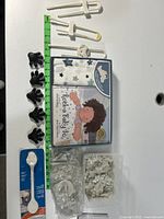 Lot displayed with a green measuring tape for scale, showing the book, blanket, clips, star stickers and white plastic item.