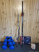 Full view of curl bar, standard press barbell, dumbbell rack with set and fitness accessories on floor