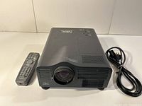 Front view of NEC MultiSync LT81 projector with lens, remote control, and power cable visible