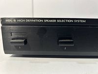 Close-up of front panel labeled HDL-6 High Definition Speaker Selection System with numbered speaker switches 1 and 2 shown.