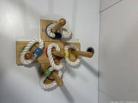 Top view of wooden ring toss game showing pegs and rope rings with colored wooden beads.
