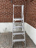 Frontal image showing the 6-foot aluminum step ladder with four wide steps and safety handrail.