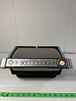 Front view of T-fal OptiGrill showing digital control panel with cooking program buttons and colorful dial.