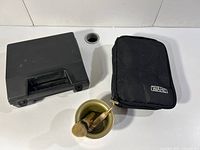 Black carrying case, Wahl branded soft case, and gold-plated shaving brush and razor set inside gold container.