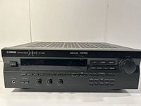 Front view of Yamaha RX-V395 home theater receiver showing control panel, display, and volume knob.