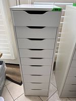 Full front view of white IKEA 9-drawer cabinet showing clean finish and drawer handles.