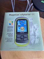 Front of box showing Magellan eXplorist GC GPS Receiver packaging with picture of device and branding information for geocaching.