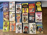 Overall view of 18 paperback books arranged in 3 rows showing various MAD titles from the 1960s and 70s with colorful illustrated covers.