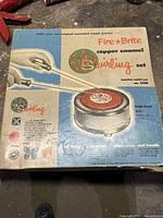 Full view of the Fire-Brite copper enamel swirling set box showing the product name and image of kiln with tools.