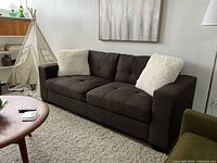 Full view of the grey chenille fabric sofa in a living room setting with white throw pillows, showcasing overall condition and design.