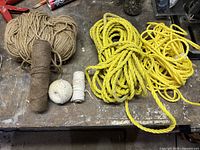 Photo of entire lot showing two thicknesses of yellow polypropylene rope, two natural fiber strings in brown, and two white strings.