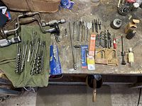 Photo showing two hand braces and a variety of drill bits including auger bits, spade bits, countersink bits, high-speed bits, and a hole saw.