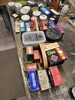 Various boxes and containers of nails and fasteners on a workbench.