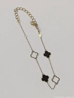 Top view of bracelet on white background showing four clover charms