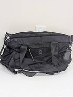Front view of black Lululemon nylon tote gym bag featuring mesh external pockets, zipper closure, and shoulder strap.