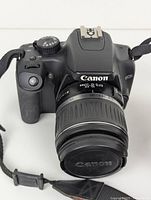 Front view of camera body with lens and strap visible