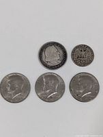 Overview of 4 American Half Dollars and 1 Quarter Dollar coin showing front faces.