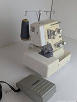Front view of serger with foot pedal on table