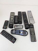 Image showing 10 remote controls arranged on a white background, from brands including Samsung, LG, Sanyo, and Sharp.