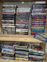Four shelf stacks of assorted DVD and Blu-Ray cases, showing various movie and TV series titles.