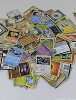 Large pile of assorted Pokemon cards showing multiple card faces including Stunfisk and others.