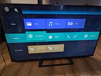 Front view of TV powered on showing settings menu