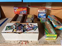 Wide view of all cards and boxed sets on a wood surface including multiple boxes and packs