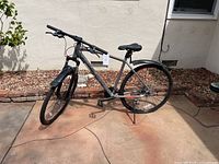 Side view of gray Hiland mountain bike showing frame, seat, handlebars, kickstand, front and rear fenders.