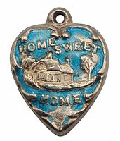 Close-up image of the front of the puffy heart charm showing blue enamel and raised 'Home Sweet Home' text with house detail.