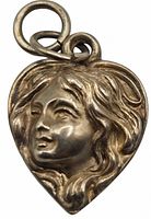 Close-up front view of the heart-shaped charm showing a raised woman's face in Art Nouveau style with detailed hair and expression, made in repoussé technique.