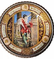 Front detail of the round antique brooch hand painted with a romantic couple scene, decorated with gold leaf, cream and burgundy accents, set in a twisted silver rim.
