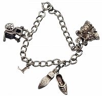 Full view of the sterling silver charm bracelet with visible charms: carriage, shoes, crown, Eiffel Tower.