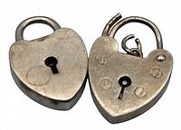 Two vintage heart-shaped sterling silver padlocks, one open showing hallmark side with initials 'E.G.S' and hallmarks, the other marked 'STERLING' on the back.