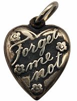 Front view of heart charm showing "Forget me not" inscription and flower details in sterling silver.
