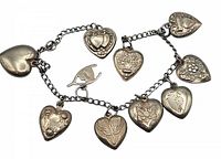 Overview of chain displaying nine puffy heart charms and one wishbone charm
