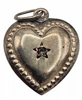 Front view of vintage sterling silver puffy heart charm featuring central clear stone in star-shaped bezel and surrounding beaded border.
