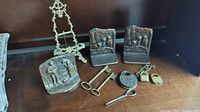 Full lot overview including bookends, keys, padlocks, easel, and screwdriver on dark wood surface