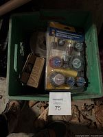 Green crate containing brush sets and other items with a MaxSold tag visible.