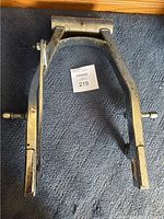 Front view of chrome swing arm showing overall shape, condition and mounting points.