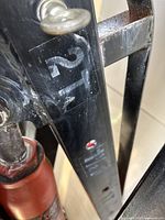 Close-up photo showing the 2T lifting capacity label on the black steel arm of the engine crane.