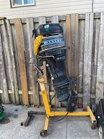 Full side view of Mercury outboard motor mounted on yellow engine stand