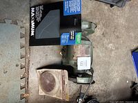 Photo of the bench grinder next to boxes of sanding discs and sandpaper showing all included items