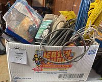 Box containing various cables, yellow straps, and packaged battery cable.